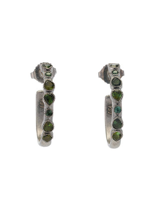 Pair of silver hoop earrings with green gemstones on a white background